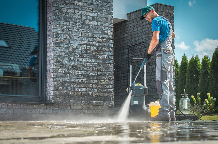 young man pressure washing